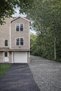 a house with a garage and a gravel driveway at Spacious 3 bedroom duplex home inside Worcester in Worcester