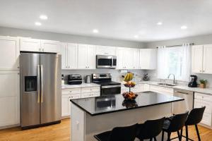a kitchen with white cabinets and a stainless steel refrigerator at Spacious 3 bedroom duplex home inside Worcester in Worcester