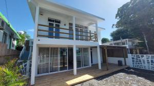 a house with large glass doors on a wooden deck at Villa SempreViva in Trou d'Eau Douce