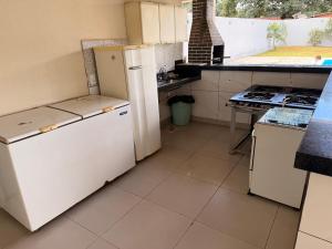 a kitchen with white appliances and a stove at Recanto do boto in Anápolis