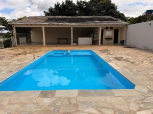 a large blue swimming pool in front of a house at Recanto do boto in Anápolis