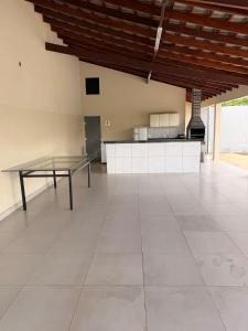 a large room with a table on a tile floor at Recanto do boto in Anápolis