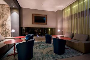Fuori le Mura في ألتامورا: لوبي الفندق مع طاولات وكراسي وأريكة