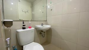 a bathroom with a toilet and a sink at Tanglin Tower with Netfix by AquHome in Surabaya +7 photos