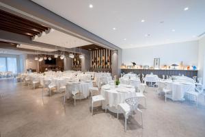 a banquet hall with white tables and white chairs at Fuori le Mura in Altamura
