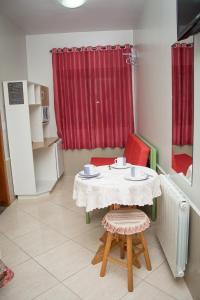 a small table with two chairs and a red curtain at Pousada Theisen in Gramado