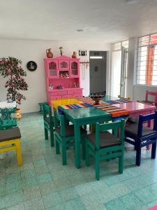 a dining room with tables and chairs and a pink cabinet at Casa Girasoles in Orizaba +17 photos