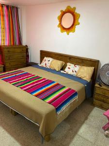 a bedroom with a bed with a colorful blanket on it at Casa Girasoles in Orizaba
