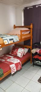 a bedroom with two bunk beds with red and white pillows at Pousada Maria Guapa 2 in São Gabriel