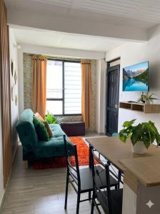 a living room with a green couch and a table at Tu Espacio en Ibague in Ibagué