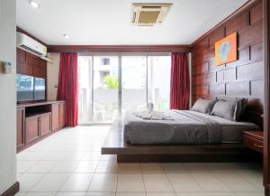a bedroom with a bed and a large window at EBS Hostel Phuket, Kata Beach in Karon Beach