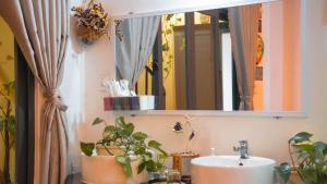 a bathroom with a sink and a mirror and plants at BắpHouseHomestay in Da Lat +49 photos