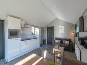 a kitchen and a living room with a couch at Callantsoog Group getaway Beach in Callantsoog
