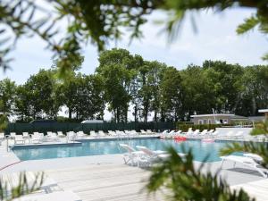 a swimming pool with white chairs and trees at Bemelen Holiday Home for 6 in Bemelen