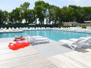 a swimming pool with white lounge chairs and a red float at Bemelen Holiday Home for 6 in Bemelen
