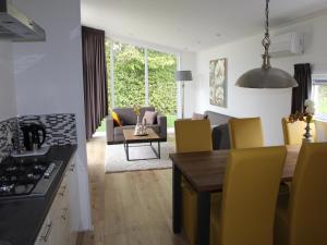 a kitchen and living room with a table and yellow chairs at Bemelen Holiday Home for 6 in Bemelen