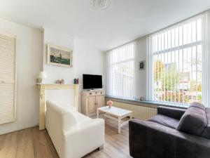 a living room with a couch and a tv at Waterside stay with Private Jetty in Heeg