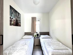 two beds in a room with white walls at Nature Park Chalet in Hoenderloo in Hoenderloo +32 photos