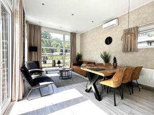 a living room with a table and chairs and a couch at Nature Park Chalet in Hoenderloo in Hoenderloo