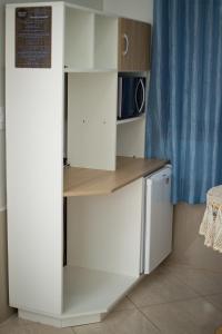 a kitchen with white cabinets and a refrigerator at Pousada Theisen in Gramado +8 photos