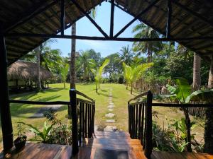 a wooden walkway leading to a resort with a yard at Binga Beach Resort in San Miguel