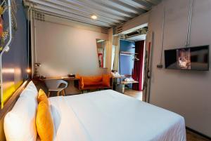 a bedroom with a bed and a desk in a room at MeStyle Garage Hotel in Bangkok