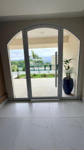 an open glass door with a potted plant in a room at Refúgio com estilo 2 Quartos 6 Pessoas in Bertioga