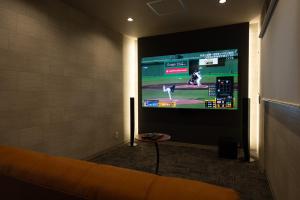 a living room with a couch and a flat screen tv at URADO TERRACE Private villa 無料駐車場4台 最大10名 桂浜近く ジャグジー シアタールーム完備 in Kochi