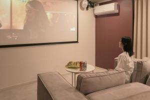 a woman sitting at a table watching a movie at Object Anook Hotel Gumi in Gumi +98 photos
