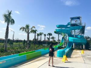 a woman standing in front of a water slide at Resort Style, close to Disney and other parks in Davenport