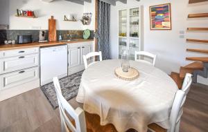 a kitchen with a white table and white cabinets at Maison Avec Piscine in Salavas