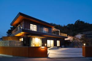 a house with a lit up facade at night at URADO TERRACE Private villa 無料駐車場4台 最大10名 桂浜近く ジャグジー シアタールーム完備 in Kochi