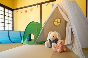 two stuffed animals sitting on a bed with a tent at URADO TERRACE Private villa 無料駐車場4台 最大10名 桂浜近く ジャグジー シアタールーム完備 in Kochi