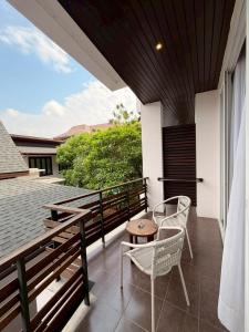 eine Terrasse mit zwei Stühlen und einem Tisch auf einem Balkon in der Unterkunft Le Patta Resort & Hotel Chiang Rai in Chiang Rai