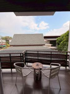 eine Terrasse mit zwei Stühlen und einem Tisch auf einem Balkon in der Unterkunft Le Patta Resort & Hotel Chiang Rai in Chiang Rai