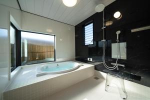 a large bathroom with a tub and a shower at URADO TERRACE Private villa 無料駐車場4台 最大10名 桂浜近く ジャグジー シアタールーム完備 in Kochi +51 photos