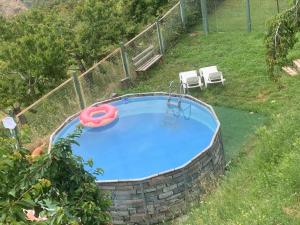 a swimming pool with a red tube in a yard at Las Casas del Nogal - Guesthouse en Sierra Nevada in Güéjar-Sierra
