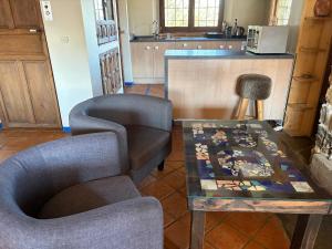 a living room with a table and two chairs and a kitchen at Las Casas del Nogal - Guesthouse en Sierra Nevada in Güéjar-Sierra