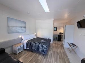 a small room with a bed and a refrigerator at Tropical City Motor Inn in Ayr