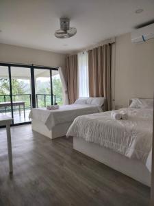 a bedroom with two beds and a balcony at Caliraya Music Camp in Cavinti