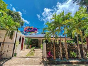 a house with palm trees in front of a fence at Caliraya Music Camp in Cavinti