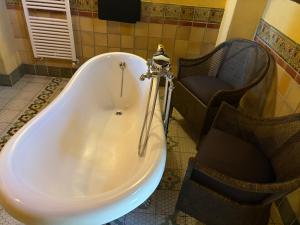 a bath tub and a chair in a bathroom at Las Casas del Nogal - Guesthouse en Sierra Nevada in Güéjar-Sierra