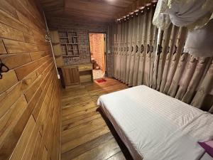 a bedroom with a bed in a wooden room at ANOR - Farmstay - Double bed in Ha Tia