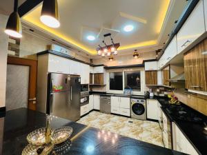 a large kitchen with a refrigerator and a dishwasher at Dreams Garden VIP Villa in Sphinx International Airport
