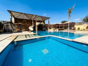 a swimming pool at a resort with a clear blue at Dreams Garden VIP Villa in Sphinx International Airport