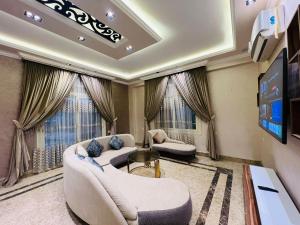 a living room with two couches and a flat screen tv at Dreams Garden VIP Villa in Sphinx International Airport
