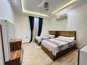 a hotel room with two beds and a tv at Dreams Garden VIP Villa in Sphinx International Airport +41 photos