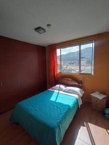 a bedroom with a bed and a large window at Hostal home 3 in Quito