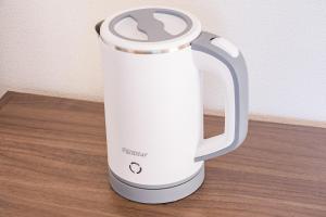 a white electric kettle sitting on a wooden table at 茜 Akane in Kawasaki