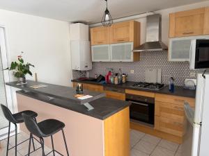 a kitchen with a counter and two stools in it at Le petit cocon in Brêmes